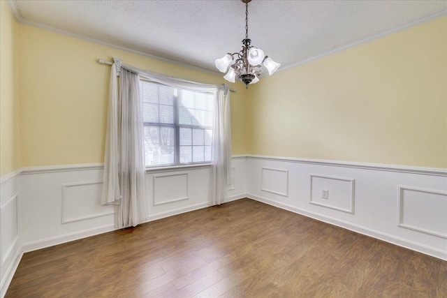 unfurnished room with ornamental molding, a chandelier, a textured ceiling, and wood-type flooring