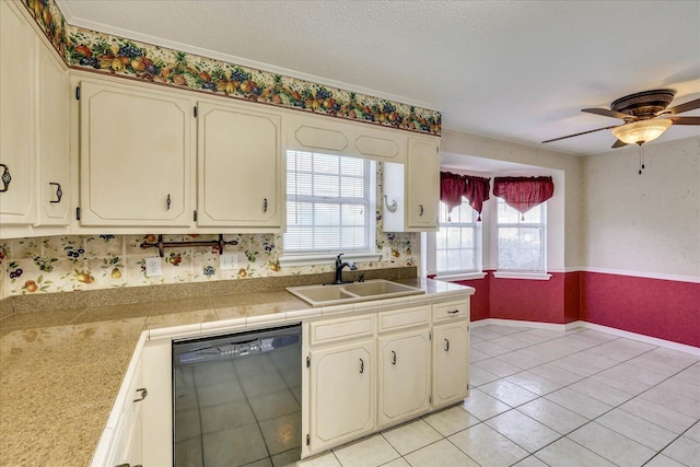 kitchen with ceiling fan, sink, black dishwasher, a textured ceiling, and light tile patterned flooring