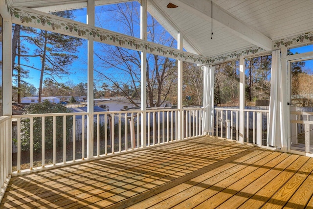 unfurnished sunroom featuring lofted ceiling with beams