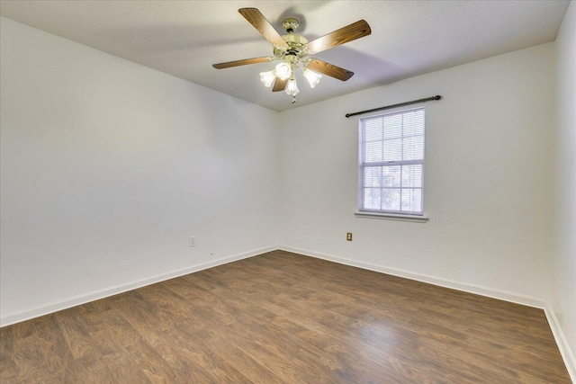 spare room featuring ceiling fan and dark wood-type flooring