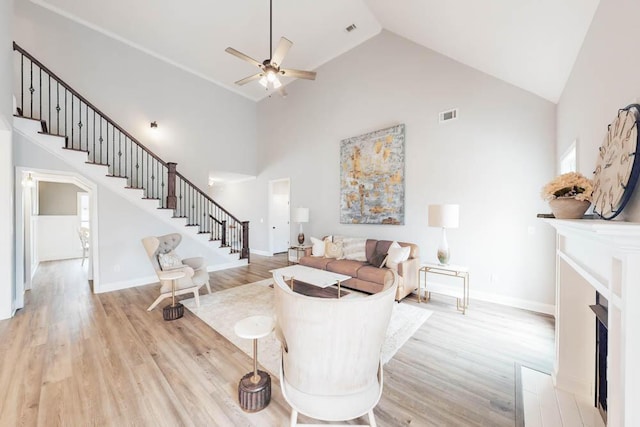 living room with a healthy amount of sunlight, high vaulted ceiling, ceiling fan, and light hardwood / wood-style floors