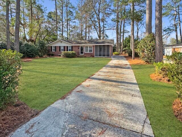 view of front of house with concrete driveway and a front yard