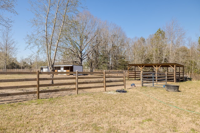 view of yard featuring an exterior structure, a rural view, and an outdoor structure