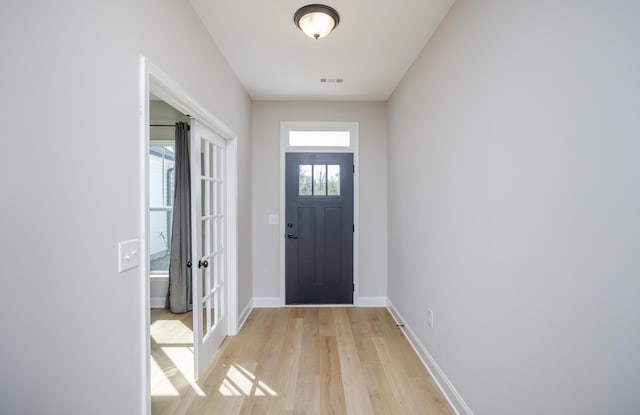 entryway with visible vents, light wood-type flooring, and baseboards