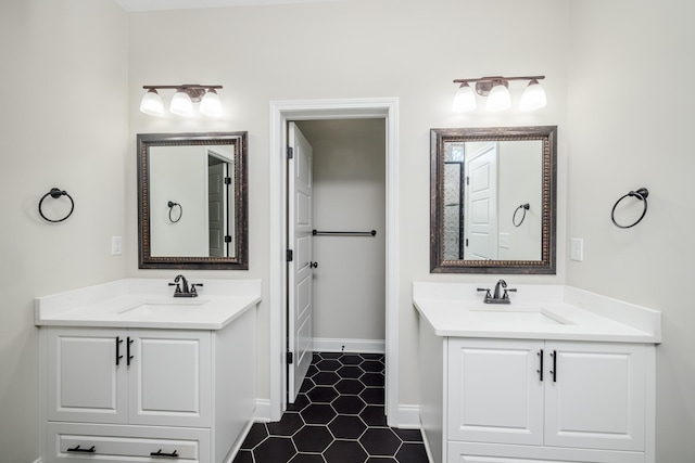 full bathroom with a sink, baseboards, and two vanities