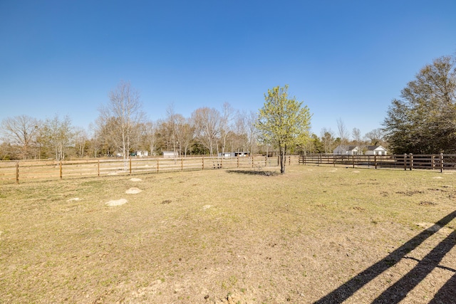 view of yard featuring a rural view and fence