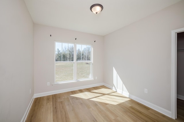 unfurnished room with baseboards and wood finished floors