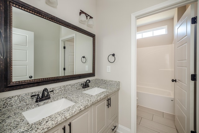 bathroom featuring double vanity, toilet, and a sink