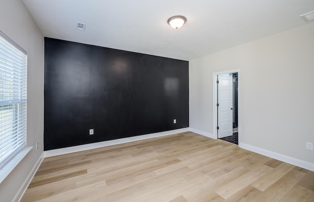 spare room with visible vents, baseboards, and light wood finished floors