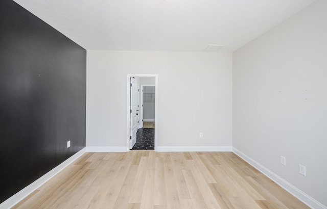 unfurnished room featuring light wood-type flooring and baseboards