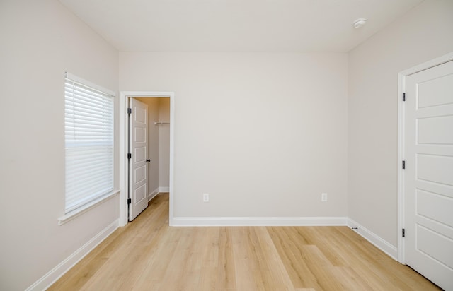 unfurnished room featuring baseboards and light wood-style flooring