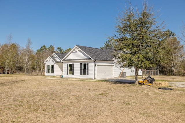 view of front facade with a front lawn, fence, and a garage