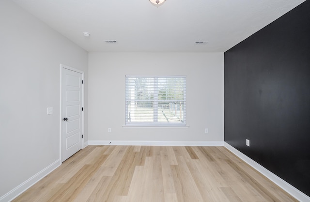 unfurnished room with visible vents, baseboards, and light wood finished floors