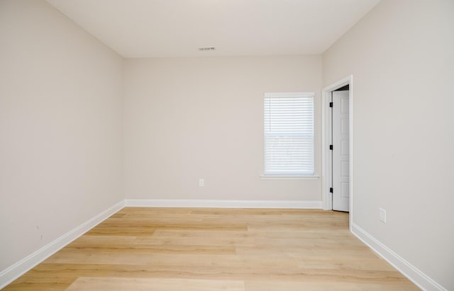 unfurnished room with light wood-type flooring, baseboards, and visible vents