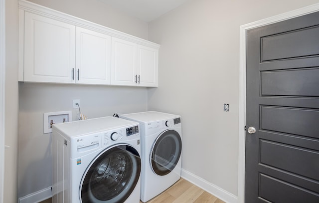 laundry room featuring cabinet space, light wood-type flooring, baseboards, and separate washer and dryer