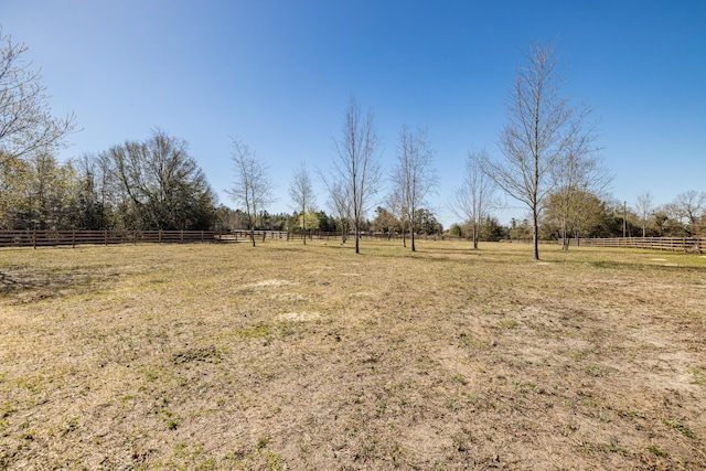 view of yard featuring a rural view and fence