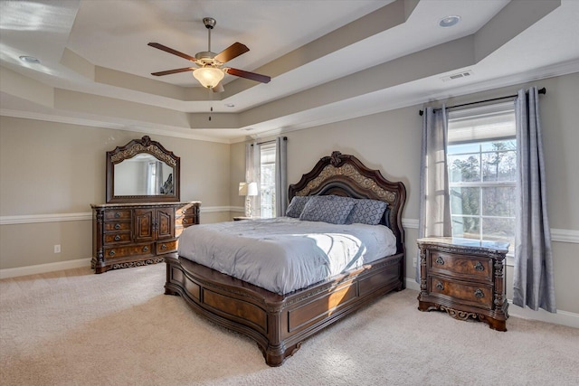 bedroom featuring a raised ceiling, ceiling fan, and carpet flooring