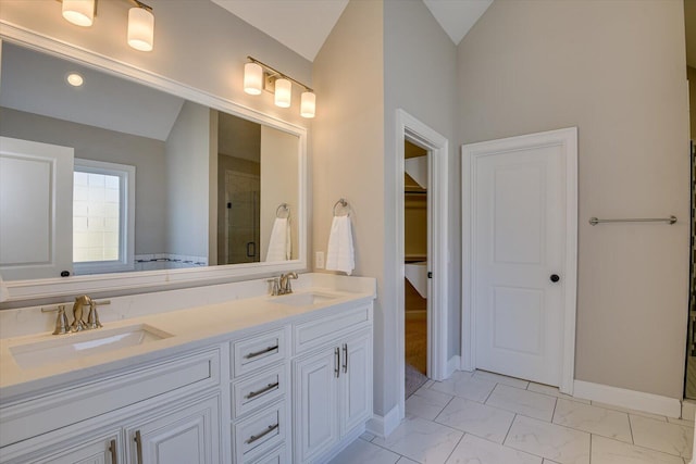 bathroom with vanity, vaulted ceiling, and a shower with door