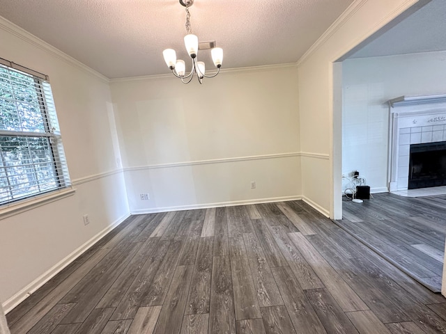 4917 Cavan Pl, Grovetown, GA 30813 - unfurnished dining area featuring dark wood-style floors, a textured ceiling, a chandelier, crown molding, and a fireplace