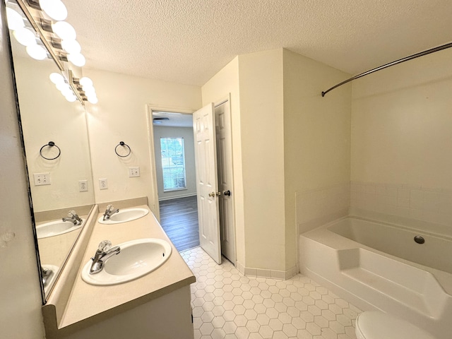 4917 Cavan Pl, Grovetown, GA 30813 - full bathroom featuring a garden tub, a textured ceiling, double vanity, and baseboards