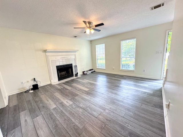 4917 Cavan Pl, Grovetown, GA 30813 - unfurnished living room featuring a ceiling fan, a textured ceiling, dark wood finished floors, a tile fireplace, and baseboards