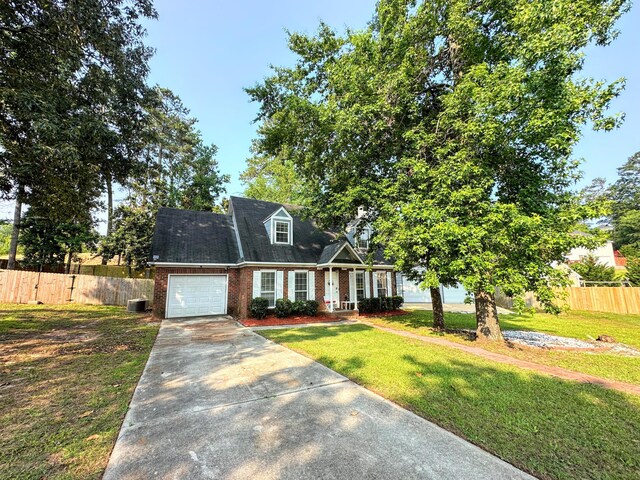 4917 Cavan Pl, Grovetown, GA 30813 - cape cod house featuring brick siding, concrete driveway, an attached garage, covered porch, and central AC