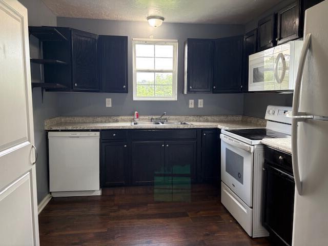 2009 Ryan Rd, Augusta, GA 30904 - kitchen with white appliances, dark wood finished floors, light countertops, blue cabinetry, and open shelves
