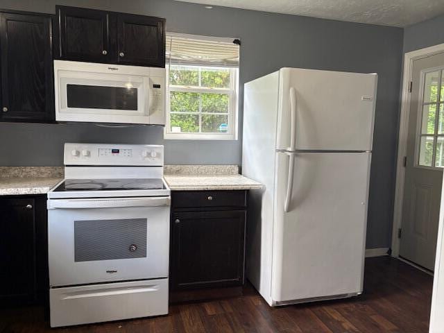2009 Ryan Rd, Augusta, GA 30904 - kitchen with white appliances, light countertops, dark cabinetry, and dark wood-style flooring