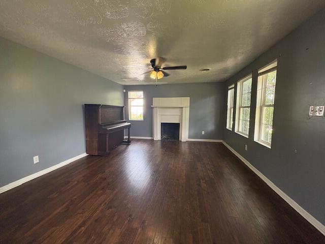 2009 Ryan Rd, Augusta, GA 30904 - unfurnished living room with ceiling fan, a textured ceiling, dark wood-type flooring, and a fireplace
