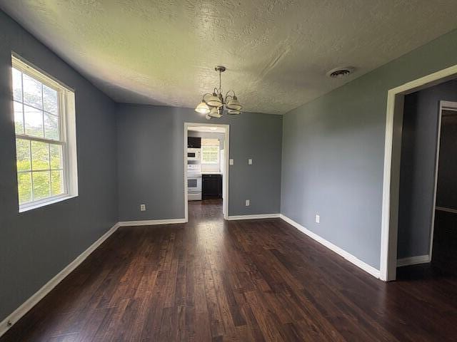 2009 Ryan Rd, Augusta, GA 30904 - unfurnished dining area featuring a textured ceiling, dark wood-style floors, and a chandelier