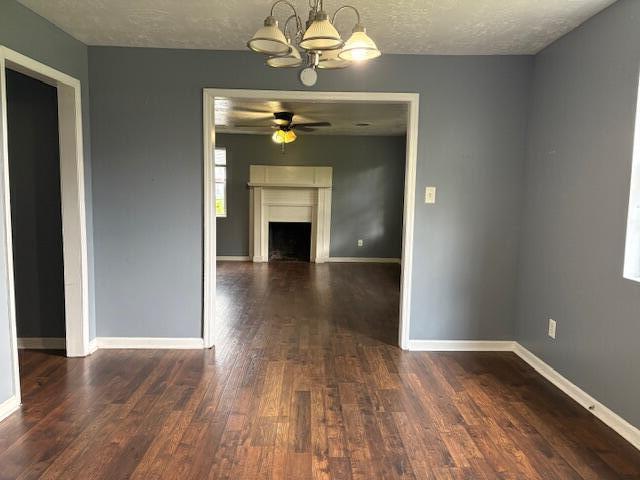 2009 Ryan Rd, Augusta, GA 30904 - unfurnished dining area featuring a chandelier, dark wood-type flooring, a ceiling fan, a fireplace, and a textured ceiling