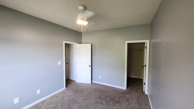 unfurnished bedroom featuring carpet, a walk in closet, and a closet