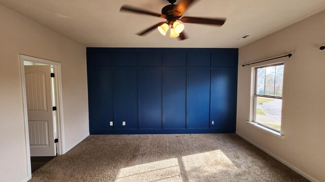 unfurnished bedroom featuring dark colored carpet and ceiling fan