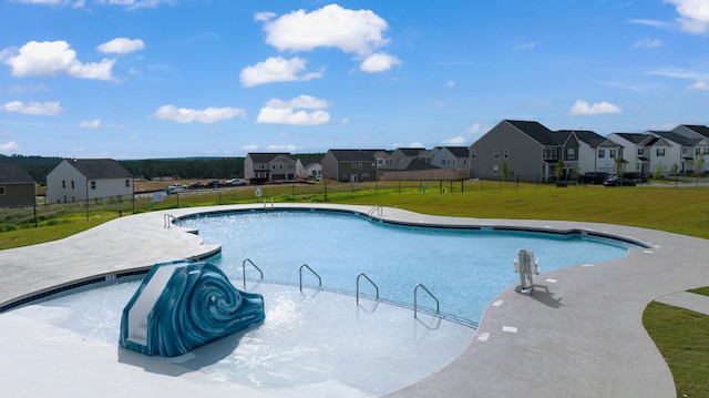 pool featuring a yard, fence, and a residential view