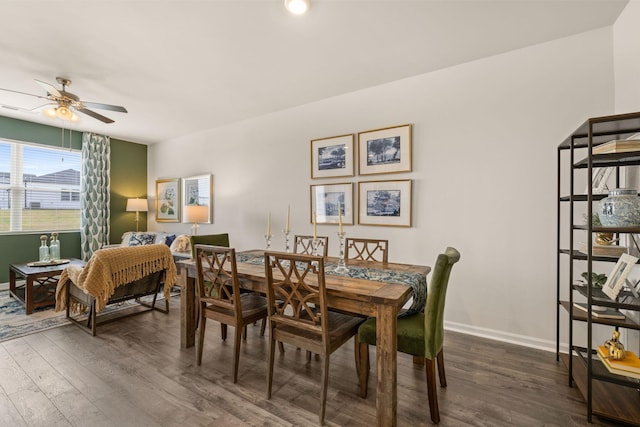 dining area featuring ceiling fan, baseboards, and dark wood-style floors