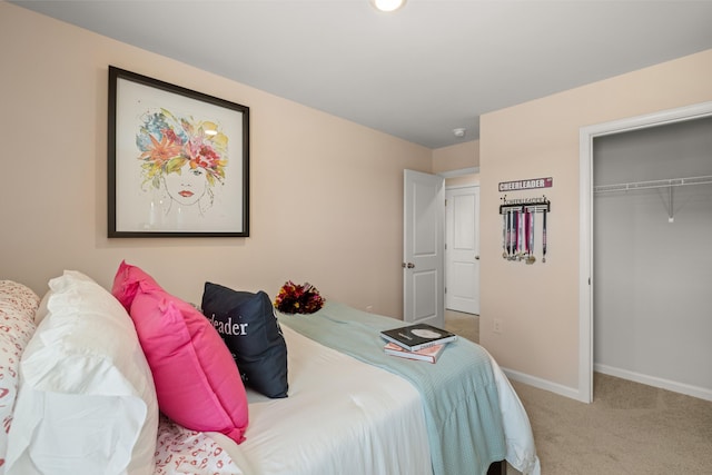 carpeted bedroom featuring baseboards and a closet