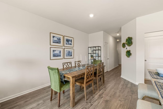 dining area with baseboards, wood finished floors, and recessed lighting