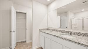 full bath with double vanity, visible vents, baseboards, and a sink