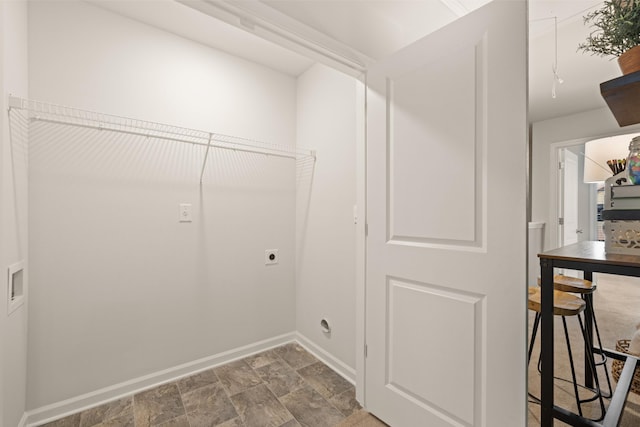 clothes washing area featuring electric dryer hookup, baseboards, stone finish floor, laundry area, and washer hookup