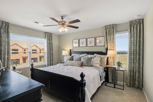 carpeted bedroom with visible vents, a ceiling fan, and baseboards