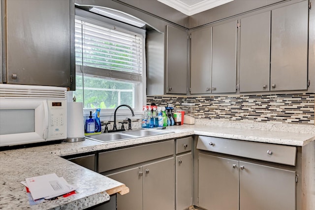 3840 Belair Rd, Augusta, GA 30909 - kitchen featuring white microwave, gray cabinetry, tasteful backsplash, light countertops, and ornamental molding