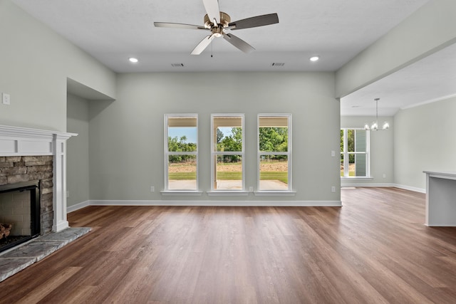 1355 Bellingham Dr, Beech Island, SC 29842 - unfurnished living room featuring ceiling fan with notable chandelier, baseboards, wood finished floors, and a stone fireplace