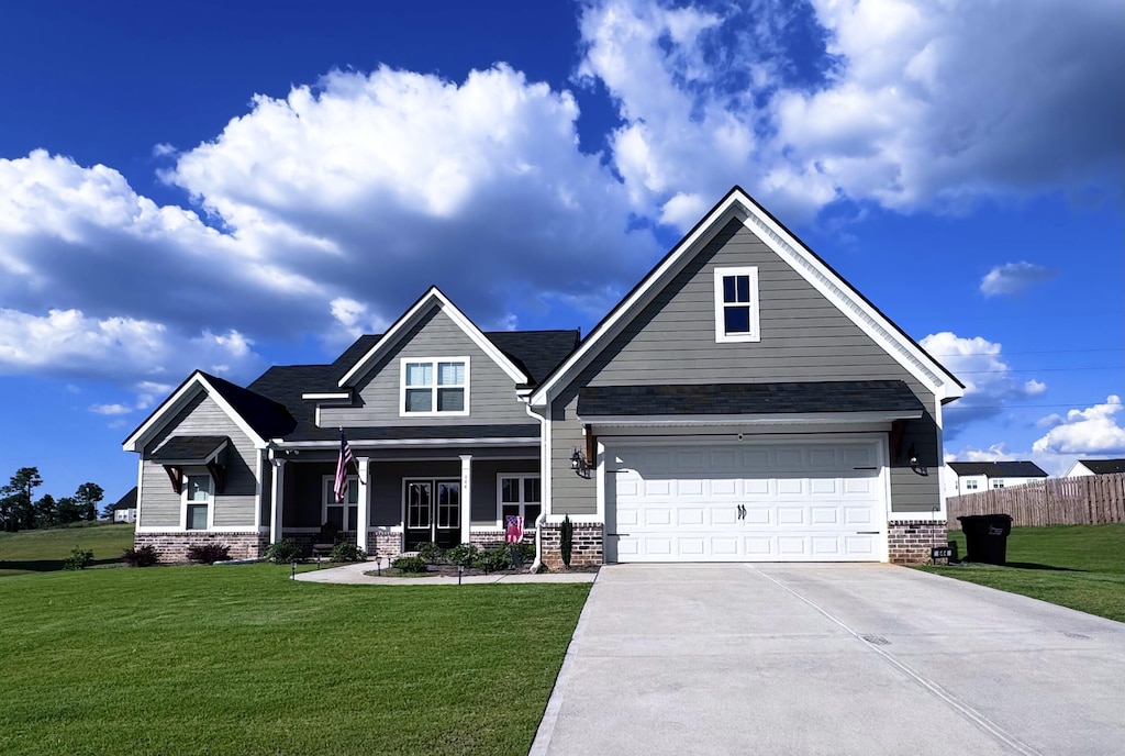 craftsman inspired home with a front lawn and a garage