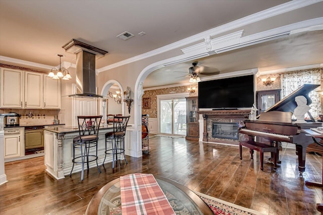 living room featuring ceiling fan, dark hardwood / wood-style flooring, and ornamental molding