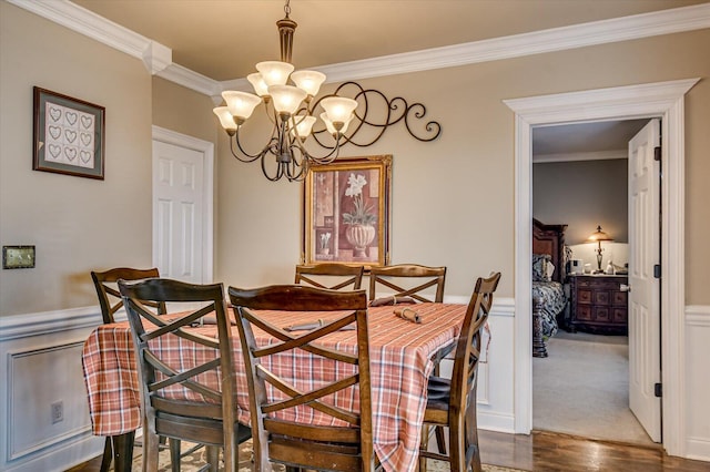 dining room featuring dark hardwood / wood-style floors, crown molding, and an inviting chandelier