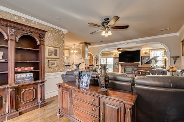 living room with ceiling fan, crown molding, and a fireplace