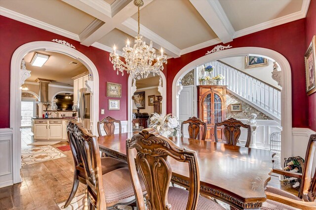 dining area featuring beam ceiling, an inviting chandelier, ornamental molding, and coffered ceiling