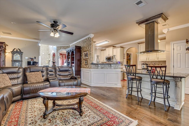 living room featuring crown molding, ceiling fan, and hardwood / wood-style flooring