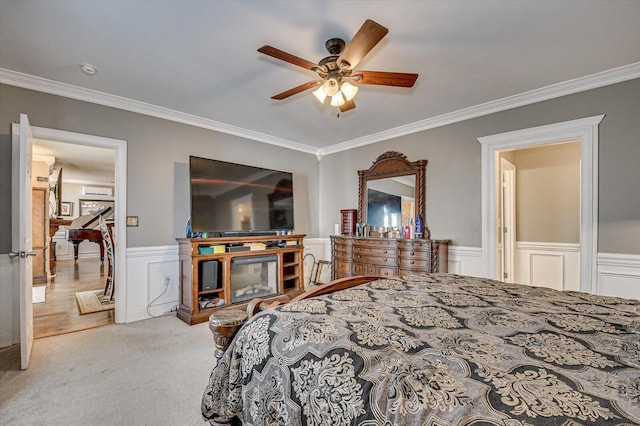 carpeted bedroom featuring ceiling fan and crown molding