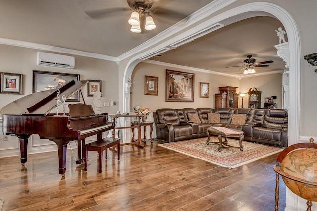 living room featuring an AC wall unit, ceiling fan, hardwood / wood-style floors, and ornamental molding